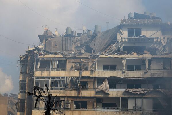 Поврежденное здание на месте израильского удара в Бейруте.