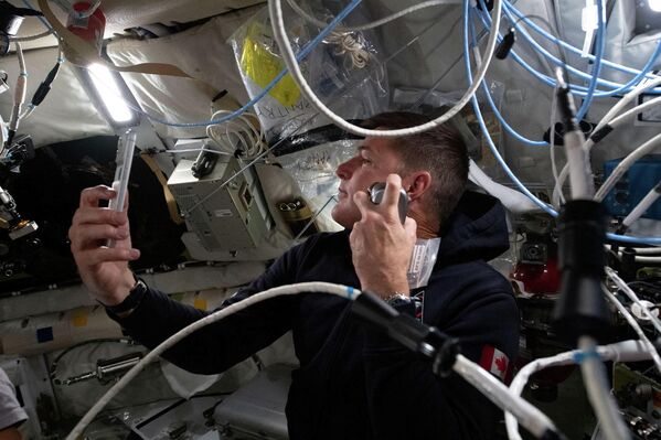 Канадский астронавт Джереми Хансен бреется на пятый день миссии.